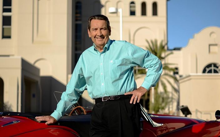 Larry Lavagnino standing in front of a red sports car