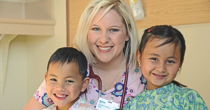 Two pediatric patients smile with Marian Regional Medical Center nurse