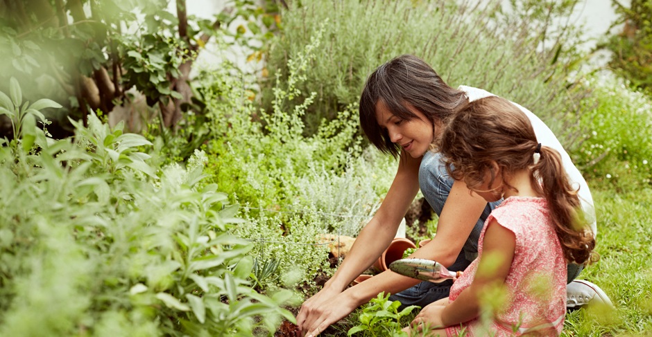 Mom helping young daughter learn about gardening