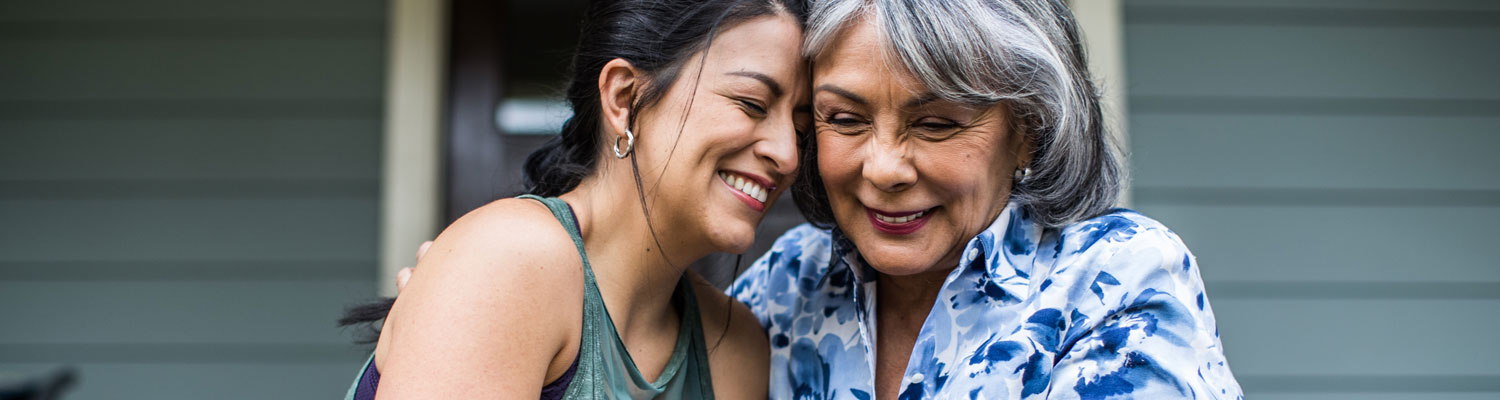 Mom and daughter smiling and hugging on porch