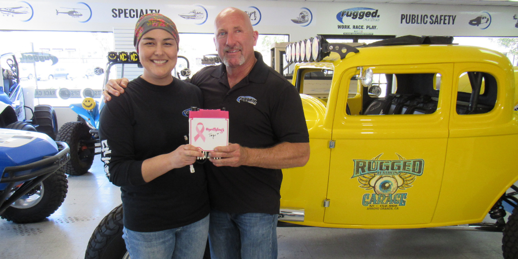 Taryn Timothy and Greg Cottrell of Rugged Radios pose with one of the special edition pink radios they sold to raise funds for cancer treatment.