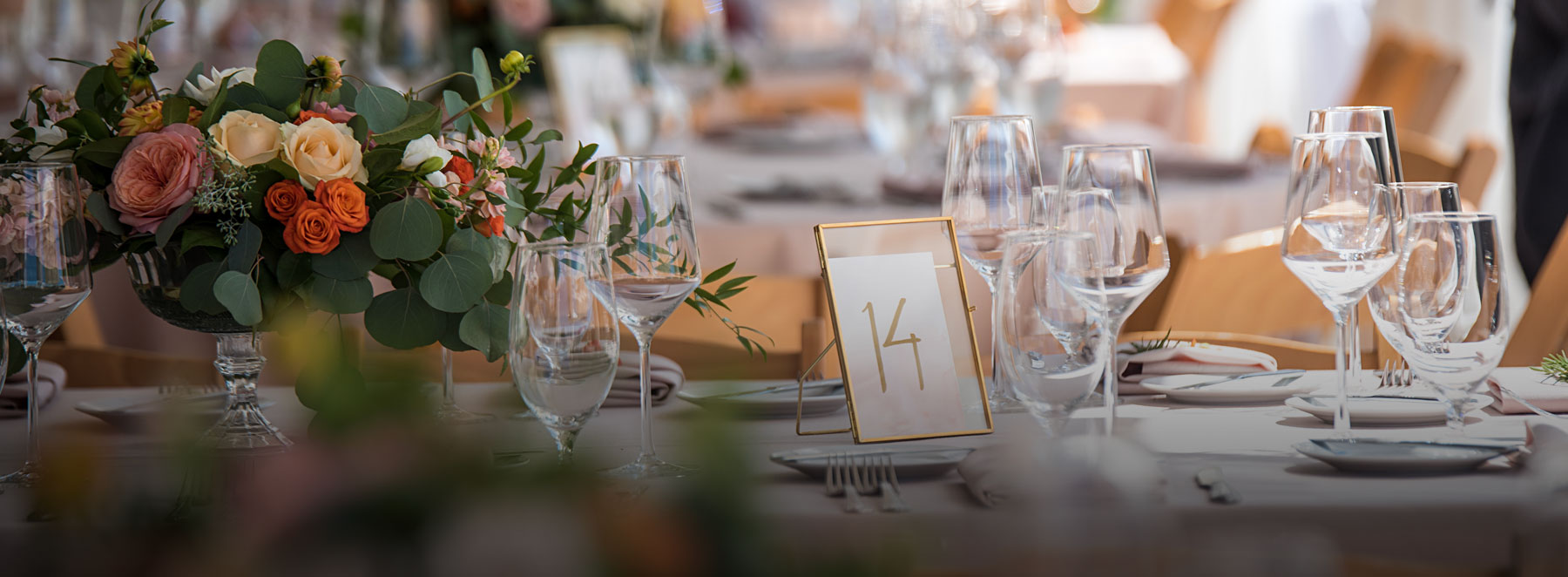 Event table decorated with fine dishes and vase of flowers