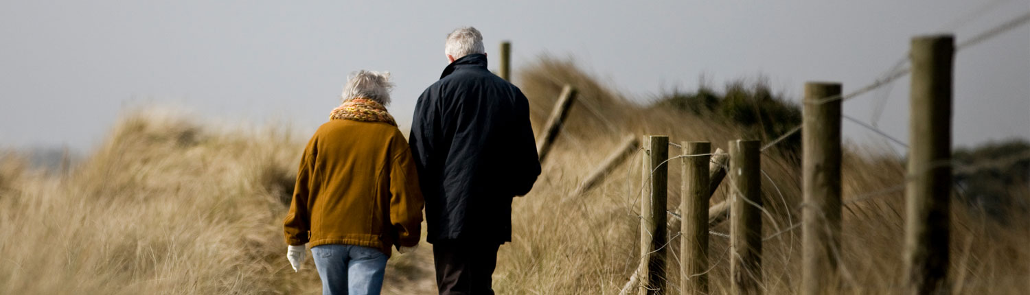 senior couple walking near beach